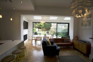 Bright and modern home extension with skylights, sliding glass doors, and cozy seating area, designed by Broadoak to maximise natural light and indoor-outdoor flow.