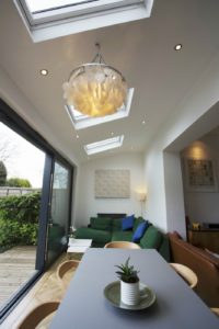 Bright and modern home extension with skylights, sliding glass doors, and cozy seating area, designed by Broadoak to maximise natural light and indoor-outdoor flow.